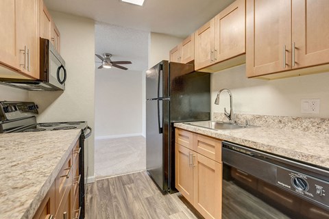 a kitchen with granite counter tops and a black refrigerator